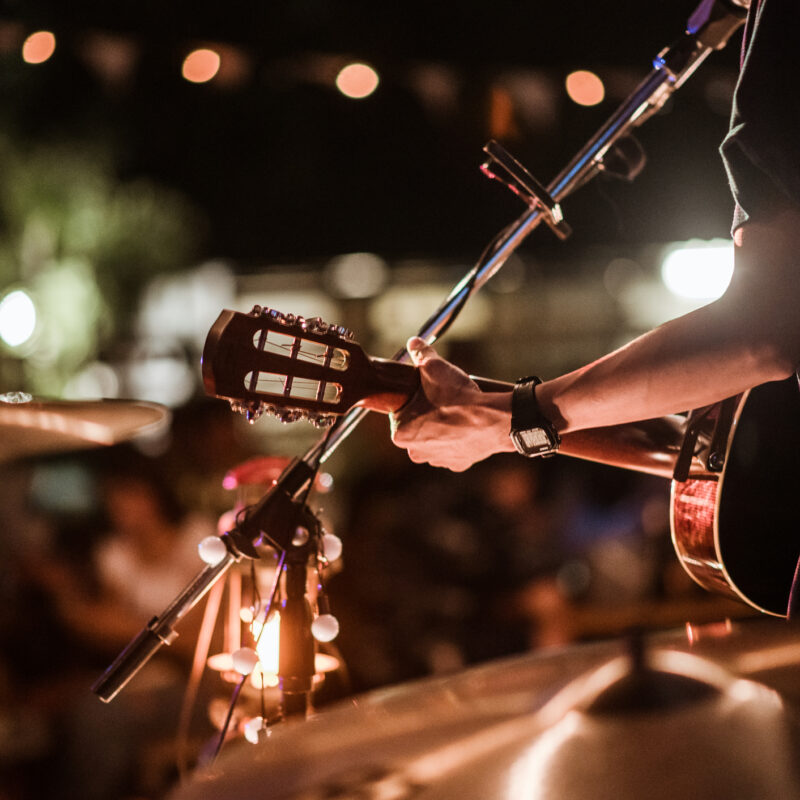 The musicians were playing rock music on stage, there was an audience full of people watching the concert. Concert,mini concert and music festivals.